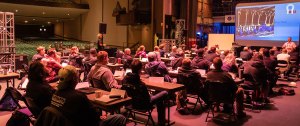 UPTW attendees sitting at tables listening to a presenter's lecture